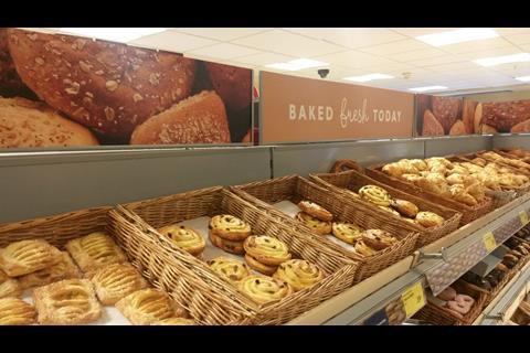 Aldi's bakery section is stocked with wicker baskets and a sign stating ‘baked fresh today’.